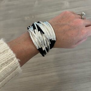 Black and silver metal tube, leather strand bracelet.